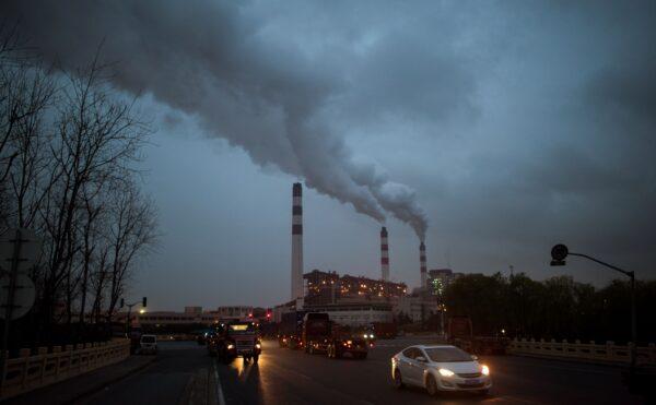 Cars pass the Shanghai Waigaoqiao Power Generator Company coal power plant in Shanghai on March 22, 2016. (JOHANNES EISELE/AFP via Getty Images)