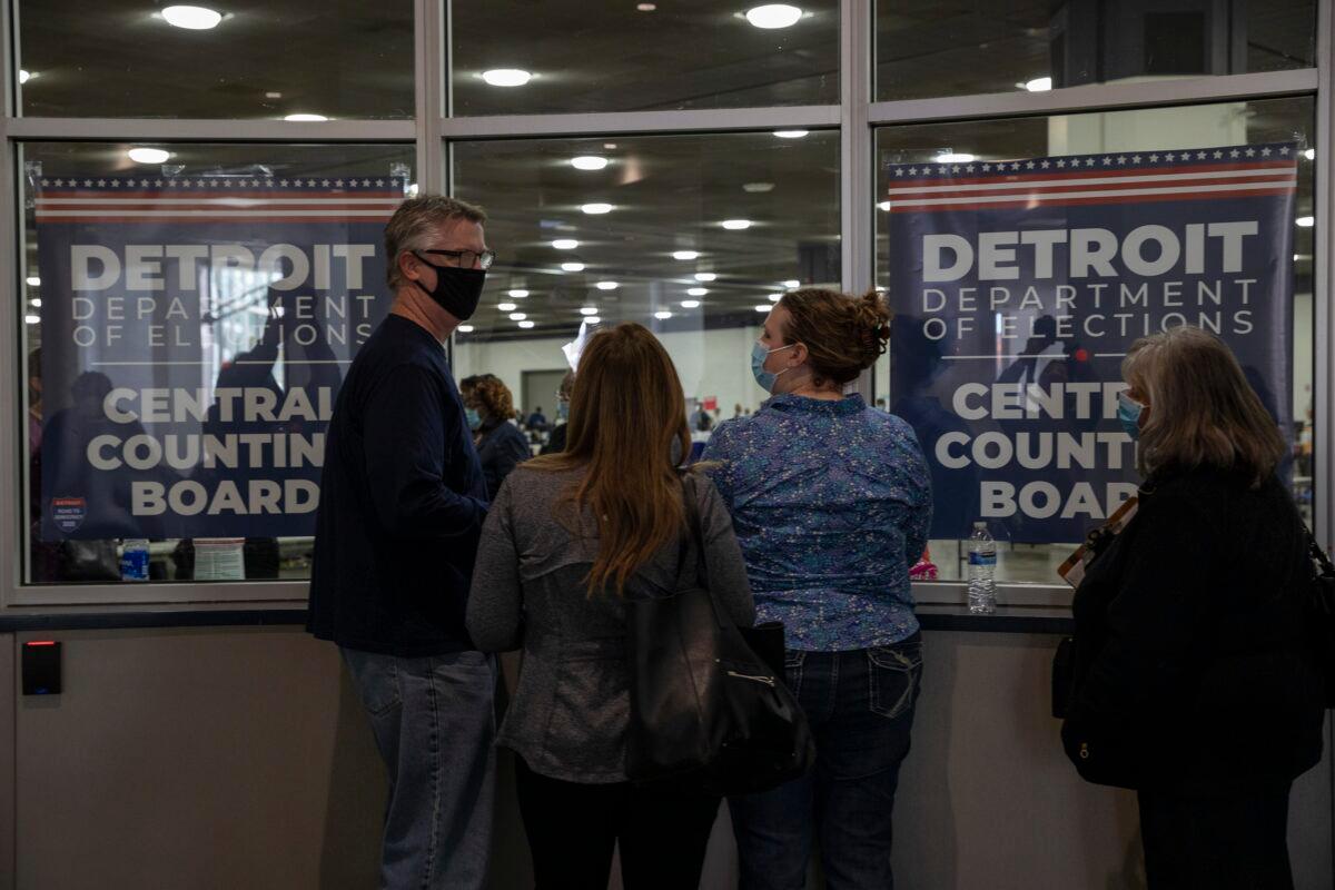 Election challengers watch through a window after being told the capacity for election challengers has been met for now at the Central Counting Board in the TCF Center in Detroit, Mich., on Nov. 4, 2020. (Elaine Cromie/Getty Images)