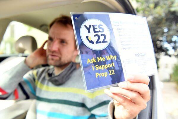 Uber driver Sergei Fyodorov holds a sign in support of Proposition 22 in Oakland, Calif., on Oct. 9, 2020. (Josh Edelson/AFP via Getty Images)
