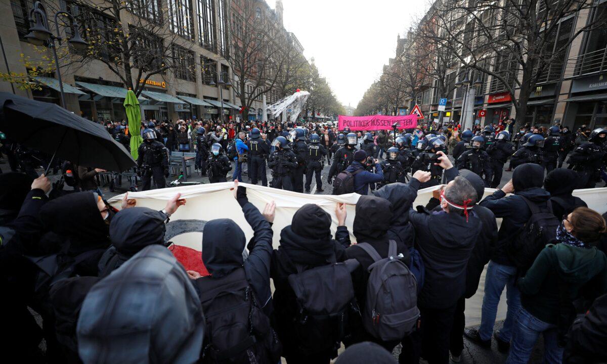 Counter-demonstrators face off people protesting against the government's restrictions amid the CCP virus disease outbreak, in Frankfurt, Germany, on Nov. 14, 2020. (Kai Pfaffenbach/Reuters)