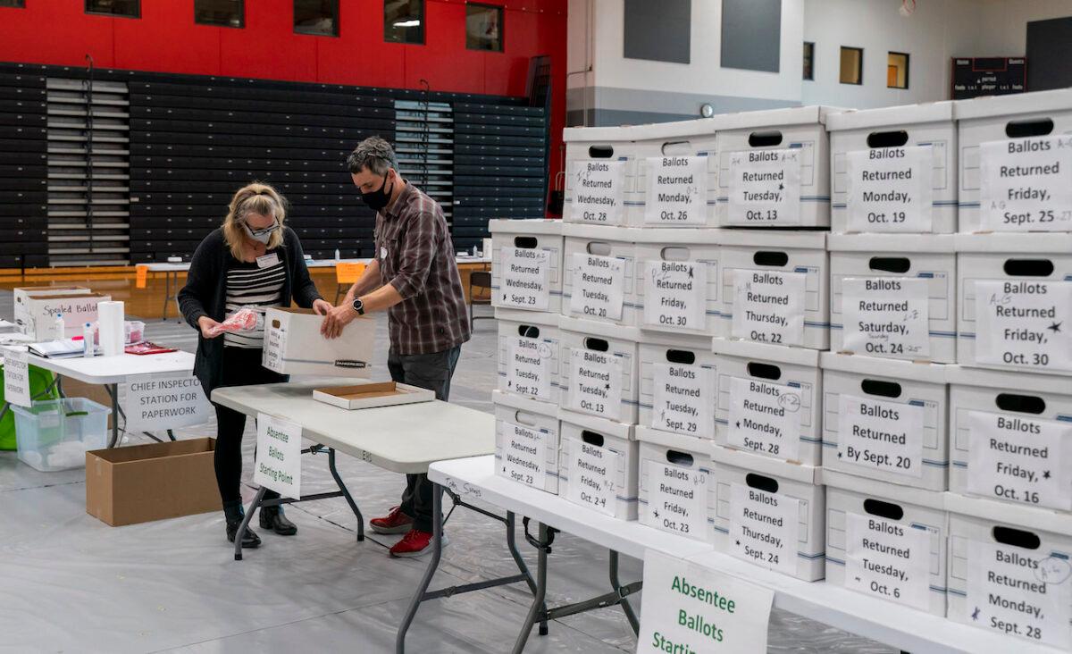  Poll workers check-in a box of absentee ballots at Sun Prairie High School in Sun Prairie, Wisconsin, on Nov. 3, 2020. (Andy Manis/Getty Images)
