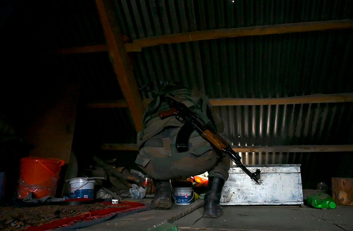 An Indian army soldier inspects a house at Sultan Daki village near the Line of Control (LOC), the de facto border between Pakistan and India, at Uri some 135 km east of Srinagar, on Nov. 14, 2020. Indian and Pakistani forces on Nov. 13 waged their biggest artillery battle of the past year, leaving more than 13 dead and dozens wounded on both sides of their disputed Kashmir frontier, officials said. (Tauseef Mustafa/AFP via Getty Images)