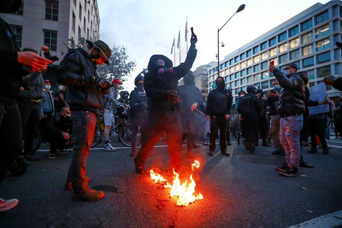 Anti-President Donald Trump demonstrators burn an American flag in Washington on Nov. 14, 2020. (Hannah McKay/Reuters)