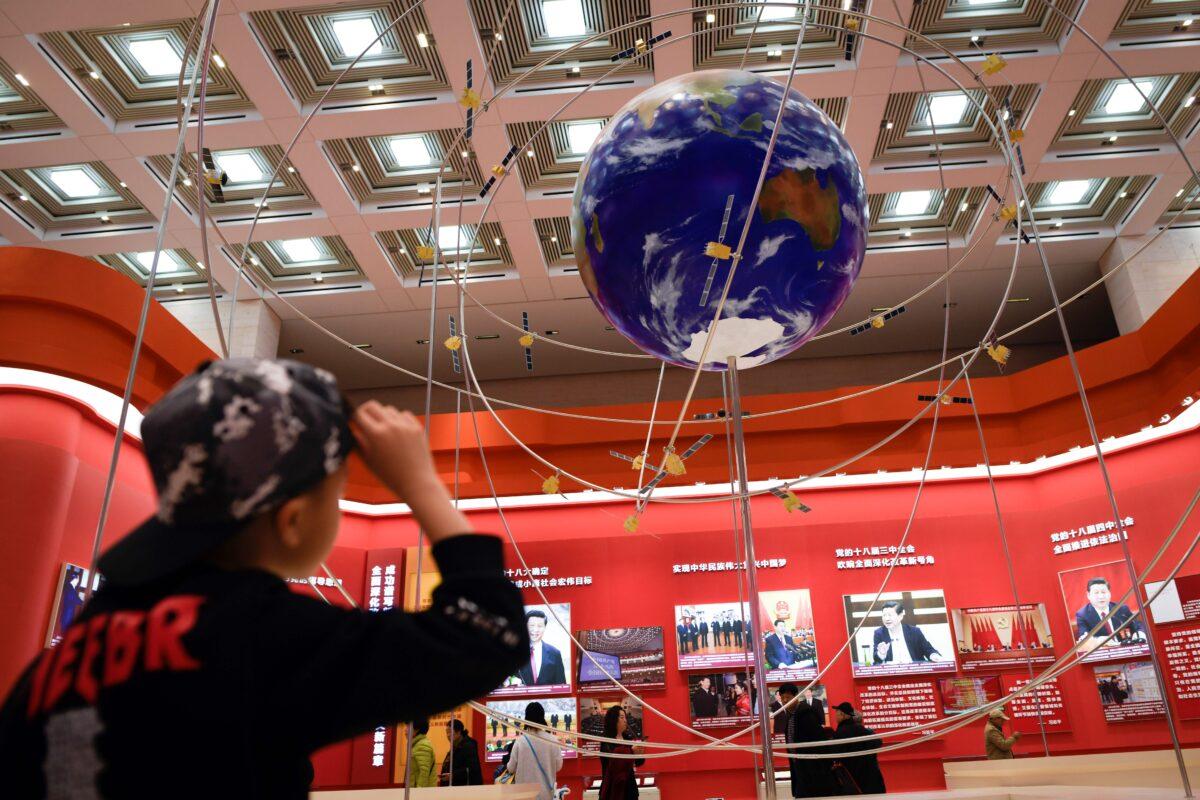 A boy looks at the BeiDou Satellite Navigation System at an exhibition at the National Museum of China in Beijing on Feb. 27, 2019. (Wamg Zhao/AFP via Getty Images)