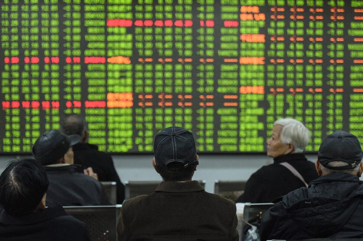 Investors look at a screen showing stock market movements at a securities company in Hangzhou, Zhejiang Province, China, on Feb. 3, 2020. (STR/AFP via Getty Images)