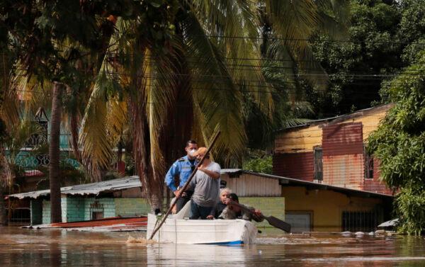 Residents paddle a boat through a flooded street in the aftermath of Hurricane Eta in Planeta, Honduras, on Nov. 5, 2020. (Delmer Martinez/AP Photo)