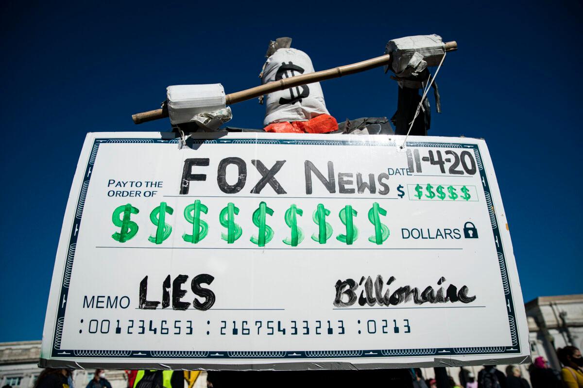 A figure holds a symbolic check during a protest from Union Station to the Fox News offices in Washington on Nov. 4, 2020. (Al Drago/Getty Images)