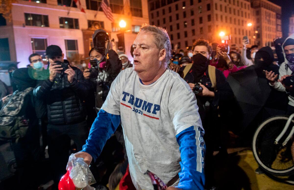 A President Donald Trump supporter is forced to leave Black Lives Matter Plaza in Washington on Nov. 14, 2020. The man was assaulted just moments after this photograph was taken. (Andrew Caballero-Reynolds/AFP via Getty Images)