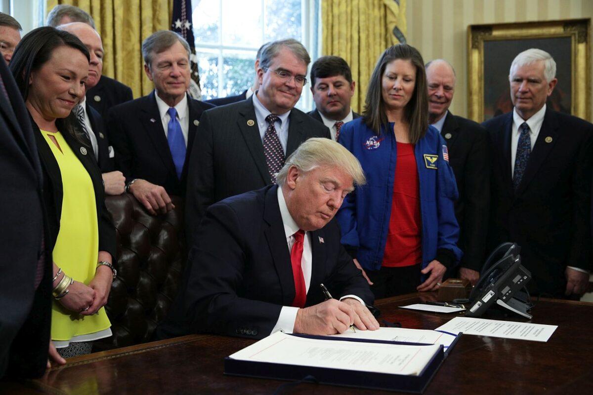 President Donald Trump participates in a bill signing ceremony as NASA astronaut Tracy Caldwell Dyson and legislators, including Rep. Martha Roby (R-Ala.), Rep. Brian Babin (R-Texas), Rep. John Culberson (R-Texas), look on in the Oval Office of the White House March 21, 2017, in Washington. (Alex Wong/Getty Images)