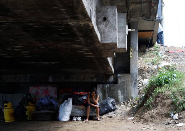 Mileydi Duarte, who was evacuated today by her family, rests under a highway bridge as she waits for space at a shelter before Hurricane Iota makes landfall in El Progreso Yoro, Honduras on Nov. 16, 2020. (Delmer Martinez/AP Photo)