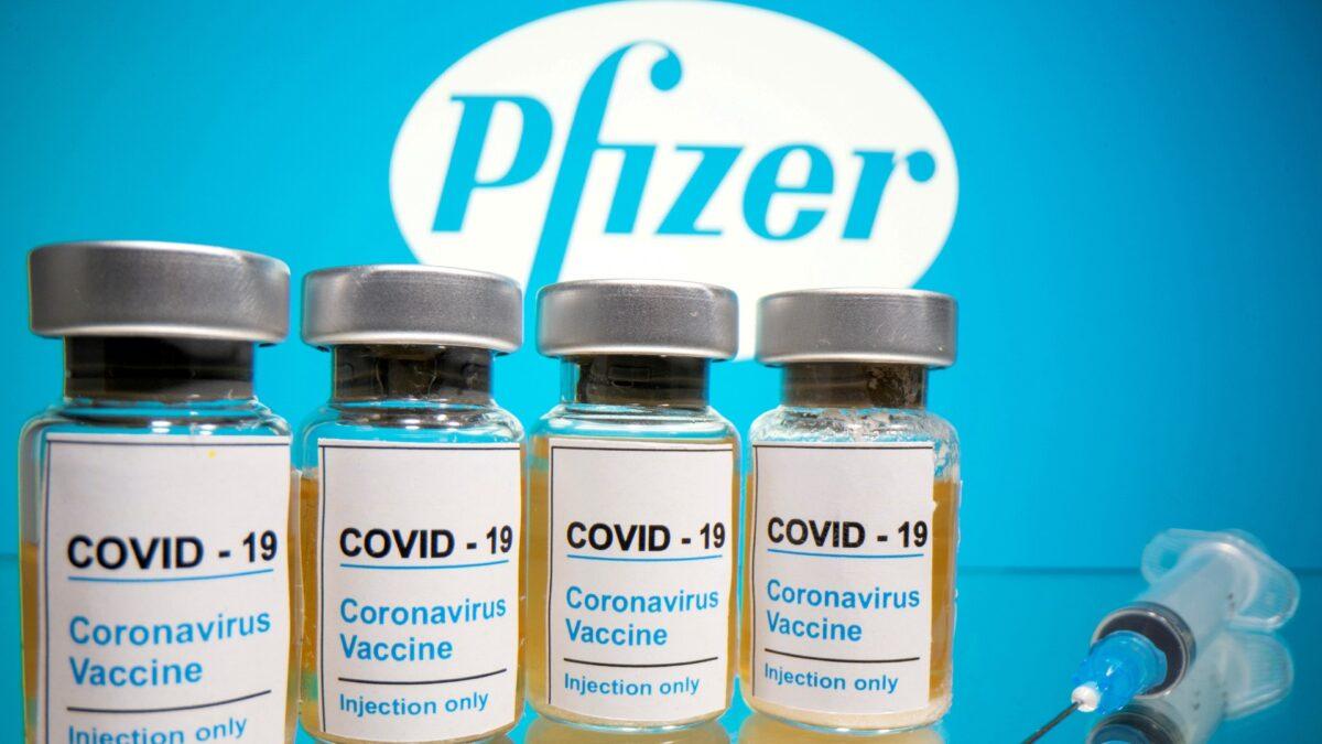  Vials of coronavirus vaccine and a medical syringe are seen in front of a displayed Pfizer logo on Oct. 31, 2020. (Dado Ruvic/Reuters)