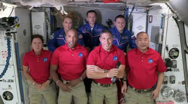 In this frame grab from NASA TV, SpaceX Dragon crew, from front left to right, Shannon Walker, Victor Glover, Mike Hopkins and Soichi Noguchi stand with International Space Station crew Kate Rubins, from back left, Expedition 64 commander Sergey Ryzhikov and Sergey Kud-Sverchkov during a welcome ceremony on Nov. 17, 2020. (NASA TV via AP)