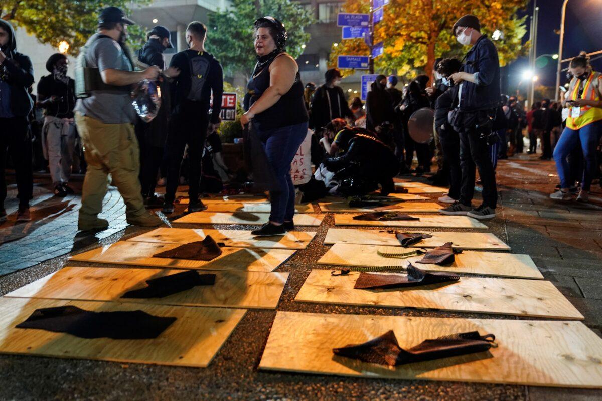 People prepare plywood shields for a march in Louisville, Ky., on Sept. 24, 2020. (Bryan Woolston/Reuters)