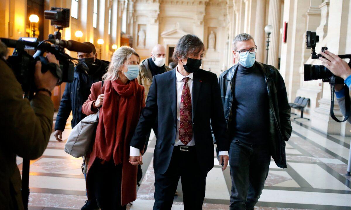 French-American Mark Moogalian, center, his wife Isabelle, left, and his lawyer Thibault de Montbrial, right, arrive at the Thalys attack trial, at the Paris courthouse, on Nov. 19, 2020. The lawyer for an American who was scheduled to testify about his role in the dramatic capture of an ISIS terrorist operative aboard a high-speed train says his witness has been hospitalized after he flew into Paris. (Francois Mori/AP Photo)