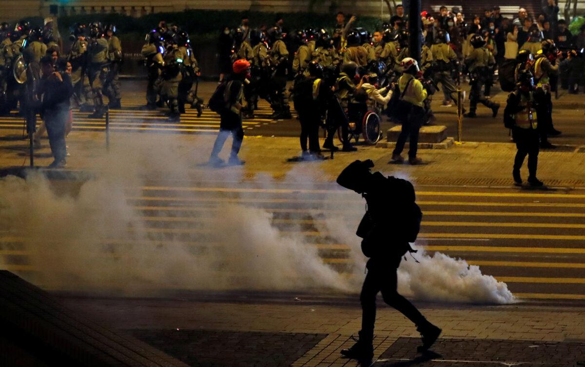 An anti-government demonstrator walks past tear gas on Christmas Eve in Hong Kong, China, Dec. 24, 2019. (Tyrone Siu/Reuters)