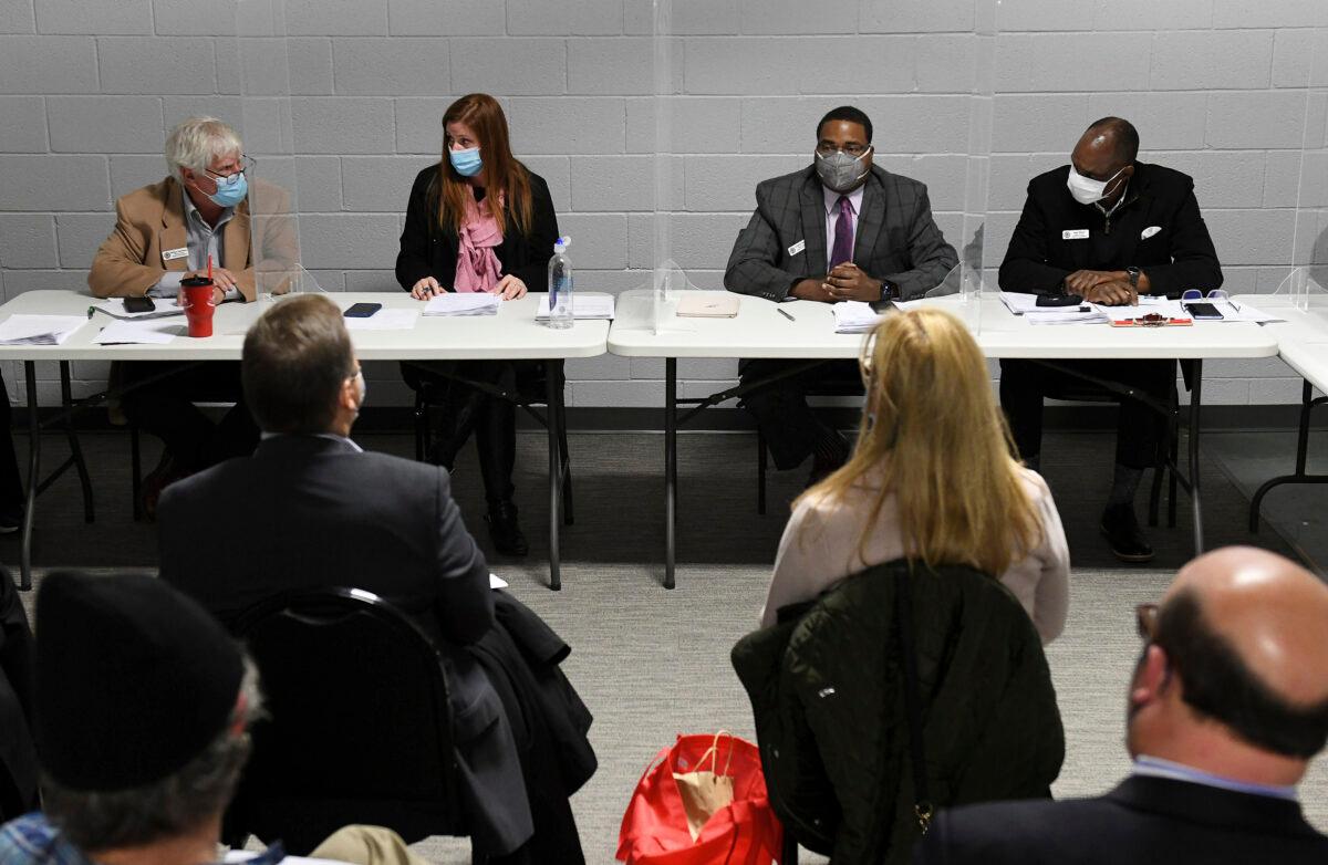 Wayne County Board of Canvassers, from left, Republican member William Hartmann, Republican chairperson Monica Palmer, Democrat vice chair Jonathan Kinloch, and Democratic member Allen Wilson discuss a motion to certify election results during a board meeting in Detroit, Mich., on Nov. 17, 2020. (Robin Buckson/Detroit News via AP)