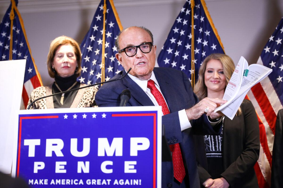 Trump lawyer and former New York City Mayor Rudy Giuliani speaks to media while flanked by attorneys Sidney Powell (L) and Jenna Ellis (R) at a press conference at the Republican National Committee headquarters in Washington on Nov. 19, 2020. (Charlotte Cuthbertson/The Epoch Times)