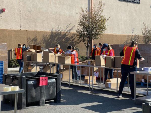 An assembly line fills boxes with prepared Thankgiving meals for the Second Harvest Food Bank in Irvine, Calif., on Nov. 19, 2020. (Drew Van Voorhis/The Epoch Times)