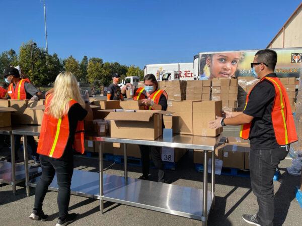 Volunteers fill boxes with food for Thankgiving Day outside the Second Harvest Food Bank in Irvine, Calif., on Nov. 19, 2020. (Drew Van Voorhis/The Epoch Times)