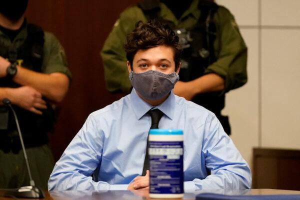 Kyle Rittenhouse, the teenager charged with killing two people and injuring another during demonstrations on the streets of Kenosha, Wisconsin, listens to defense attorney John Pierce during an extradition hearing in Lake County in Waukegan, Ill., on Oct. 30, 2020. (Nam Y. Huh/Pool via Reuters/File Photo)