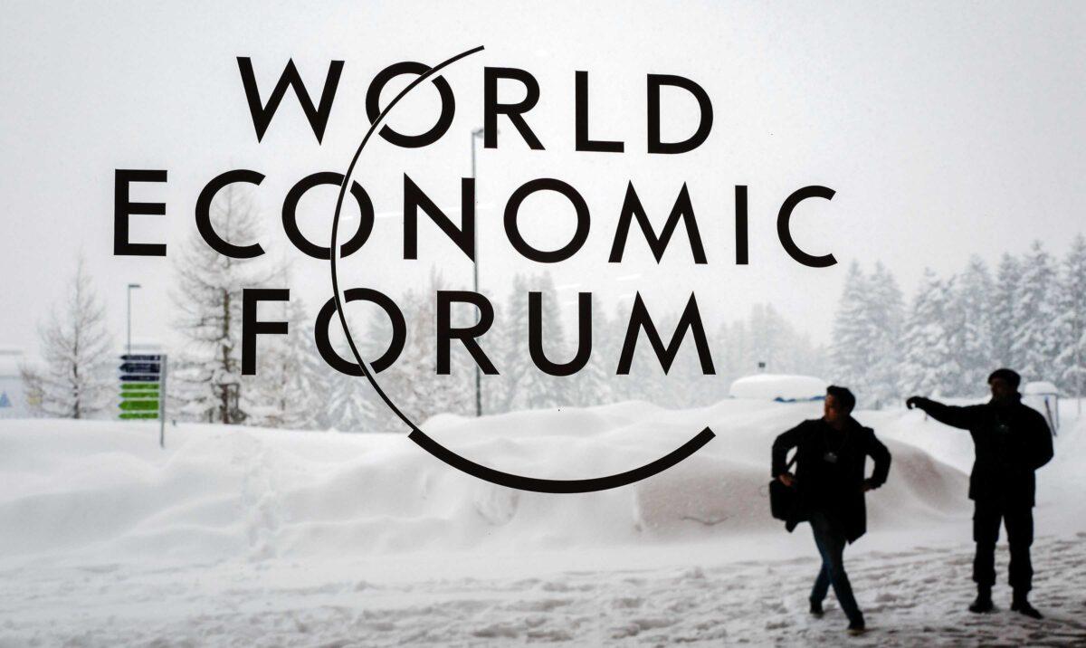 A security guard shows the way to a man outside of the Davos Congress Centre under snow ahead of the opening of the World Economic Forum (WEF) 2018 annual meeting, in Davos, Switzerland, on Jan. 22, 2018. (Fabrice Coffrini/AFP via Getty Images)