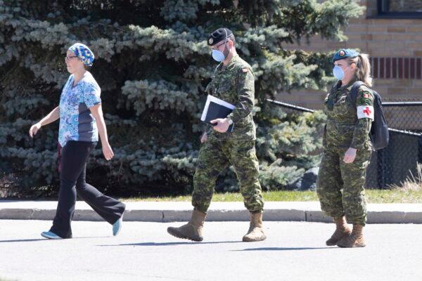 A staff member escorts members of the Canadian Armed Forces to a long-term care home in Pickering, Ont., on April 25, 2020. (Chris Young/The Canadian Press)