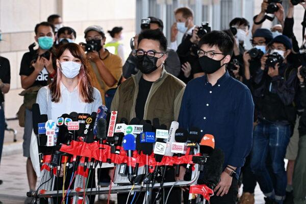 (L-R) Agnes Chow, Ivan Lam, and Joshua Wong speak to reporters before their court session in Hong Kong on Nov. 23, 2020. (Song Bilung/The Epoch Times)