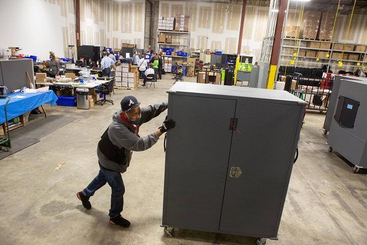  A Fulton County employee moves voting machine transporters to be stored at the the Fulton County Election Preparation Center in Atlanta, Ga., on Nov. 4, 2020. (Jessica McGowan/Getty Images)