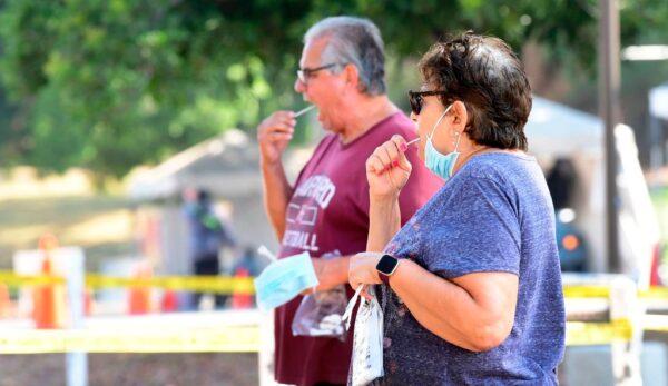 People swab their mouths for a COVID-19 test in Los Angeles, Calif., on Sept. 4, 2020. (Frederic J. Brown/AFP via Getty Images)