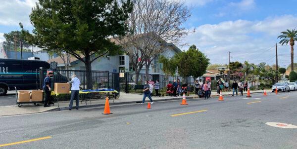 Pedestrians and cars line up early for prepared Thanksgiving meals in Orange, Calif., on Nov. 23, 2020. (Drew Van Voorhis/The Epoch Times)