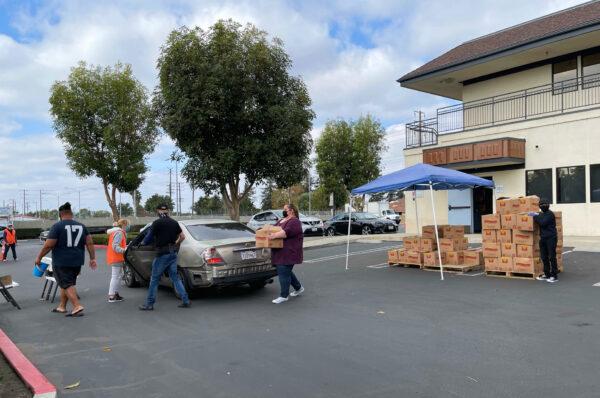 Volunteers distribute boxes of food supplies at the First Assembly Church in Santa Ana, Calif., on Nov. 23, 2020. (Drew Van Voorhis/The Epoch Times)