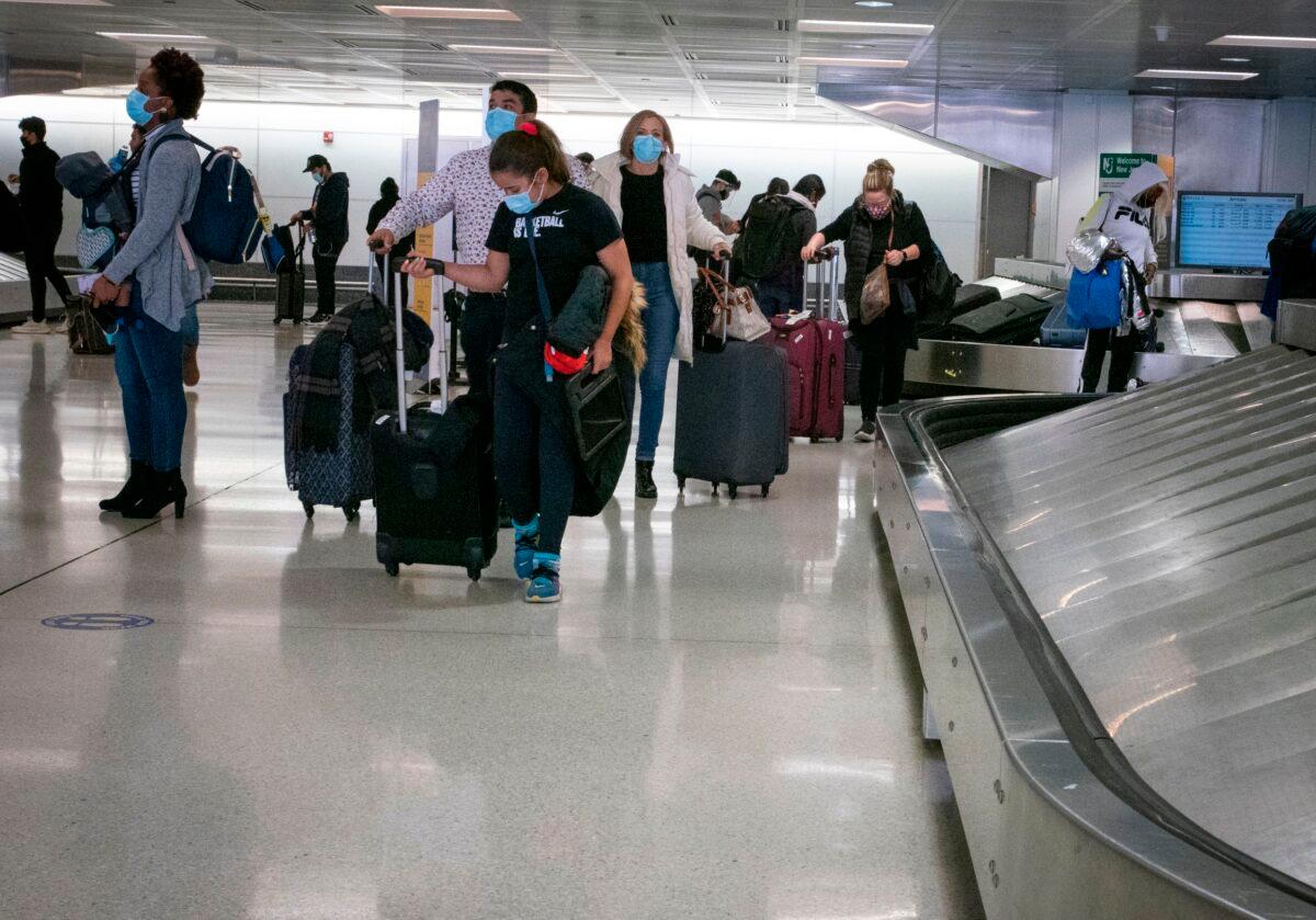 Travelers retrieve their luggage at Newark International Airport in Newark, N.J., on Nov. 21, 2020. (Kena Betancur/AFP via Getty Images)