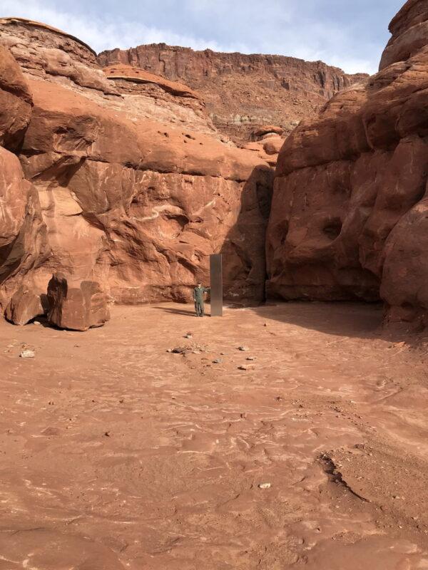 A Utah Department of Public Safety Aero Bureau and Utah Division of Wildlife Resources crew member stands near a metal monolith discovered in a remote area of Red Rock Country in Utah, on Nov. 18, 2020. (Utah Department of Public Safety via Reuters)