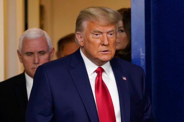 President Donald Trump, followed by Vice President Mike Pence, left, walks into the briefing room at the White House in Washington, on Nov. 24, 2020. (Susan Walsh/AP Photo)