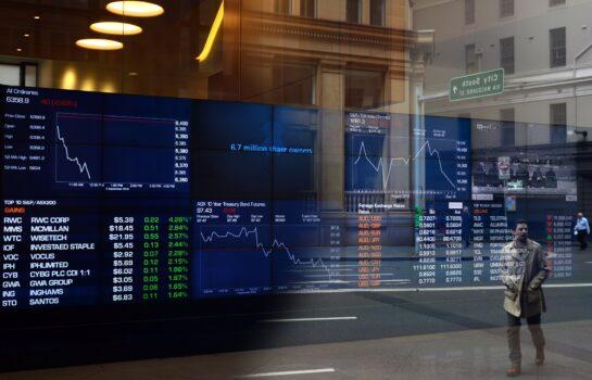A pedestrian, reflected in a window of the Australian Securities Exchange (ASX), looks at a screen showing financial data in Sydney on September 5, 2018. - (Saeed Khan/AFP via Getty Images)