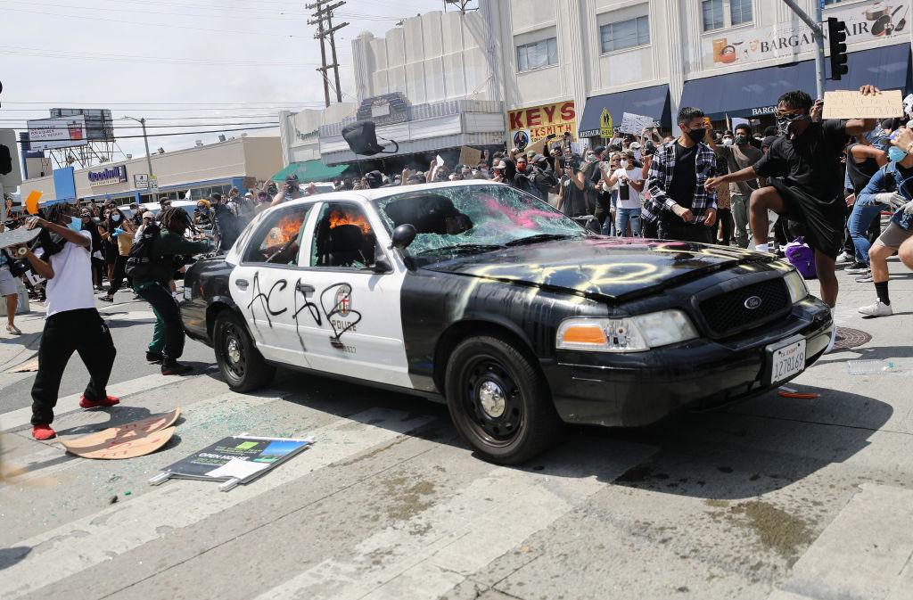 A Los Angeles Police Department vehicle is set alight by protesters during demonstrations in Los Angeles on May 30, 2020, following the death of George Floyd. (Mario Tama/Getty Images)
