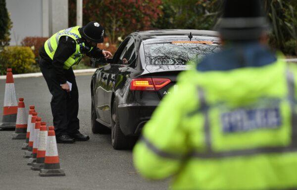 During the first national lockdown, police officers from North Yorkshire Police stop motorists in cars to check that their travel is "essential", in line with the British government's COVID-19 advice in York, northern England, on March 30, 2020. (Oli Scarff/AFP via Getty Images)