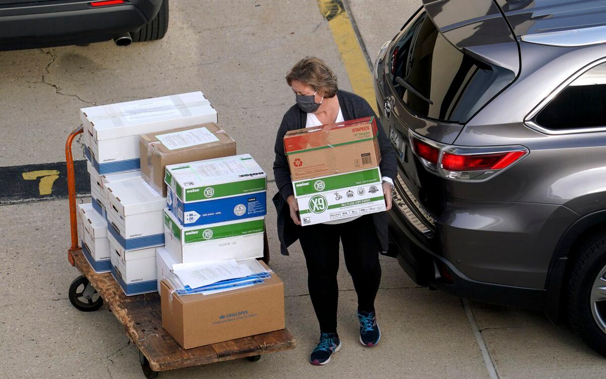 Election officials from around Dane County bring ballots into the Monona Terrace in Madison, Wis., for a recount, on Nov. 19, 2020. (Steve Apps/Wisconsin State Journal via AP)