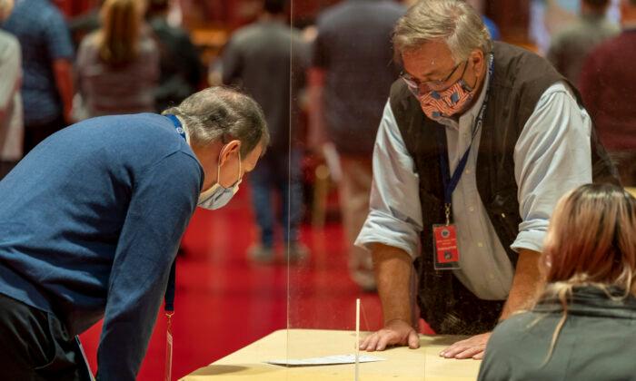 Dane County, Wis., health orders require that masks be worn inside buildings open to the public. Masked volunteers work the presidential recount in Madison, Wis., on Nov. 20, 2020. (Andy Manis/Getty Images)