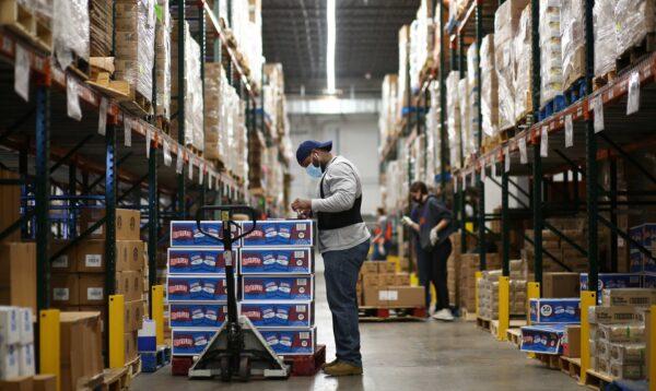 A staff member at Food Bank of the Rockies stocks boxes of food in their warehouse to be distributed to people in need ahead of Thanksgiving in Denver, on Nov. 25, 2020. (Kevin Mohatt/Reuters)