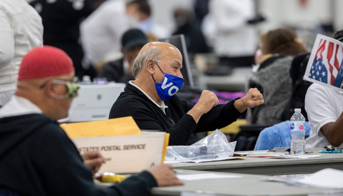 A worker with the Detroit Department of Elections celebrates after hearing the nearly final number of 167,000 absentee ballots that were counted is announced over the loudspeaker at the Central Counting Board in the TCF Center in Detroit, Mich., on Nov. 4, 2020. (Elaine Cromie/Getty Images)