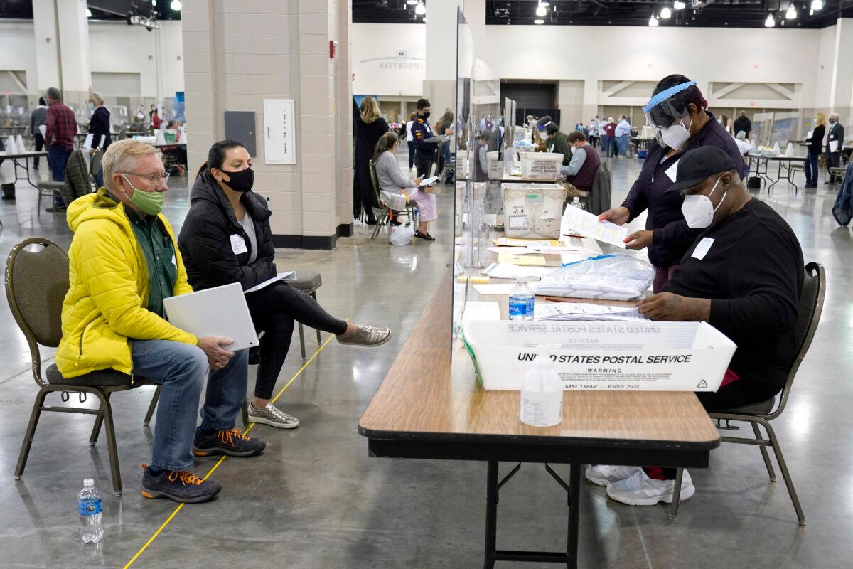  Election workers (R) verify ballots as recount observers (L) watch during a Milwaukee hand recount of presidential votes at the Wisconsin Center in Milwaukee, Wis., on Nov. 20, 2020. (Nam Huh/AP Photo)