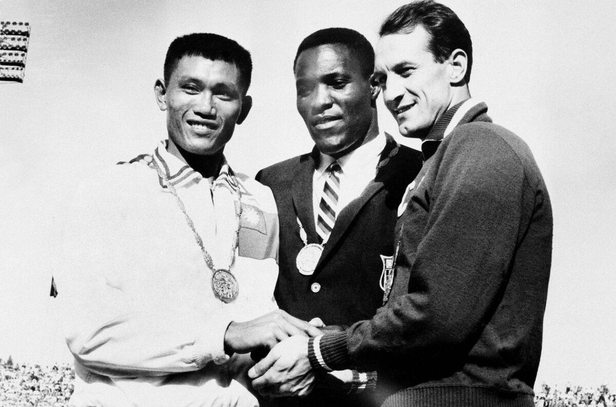 Rafer Johnson of Kingsburg, Calif., is flanked by runners-up, Chuan-Kwang Yang, left, of Taiwan, and Vasily Kuznetsov of Russia, as they join in three-way handshake after receiving medals for the decathlon event of the Olympics in Rome, Italy, on Sept. 7, 1960. (AP Photo)