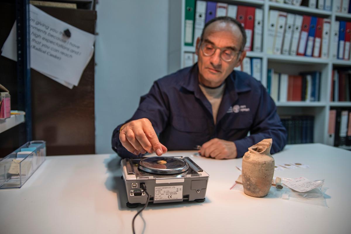 Dr. Robert Kool examining the coins (Photo: Shai Halevi, <a href="http://www.antiquities.org.il/">Israel Antiquities Authority</a>)