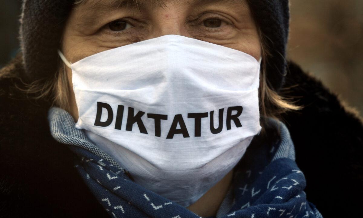 A woman wearing a protective mask reading ''dictatorship'' protests against government restrictions in Bremen, Germany, on Dec. 5, 2020. (Fabian Bimmer/Reuters)