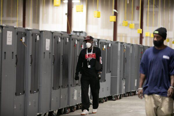 Fulton County employees walk amongst voting machine transporters being stored at the Fulton County Election Preparation Center, in Atlanta, Ga., on Nov. 4, 2020. (Jessica McGowan/Getty Images)