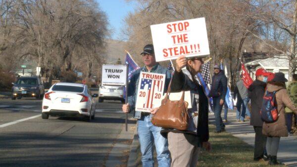 Cars pass by as rally-goers hold signs outside the Carson City Courthouse in Carson City, Nev., on Dec. 3, 2020. (NTD)