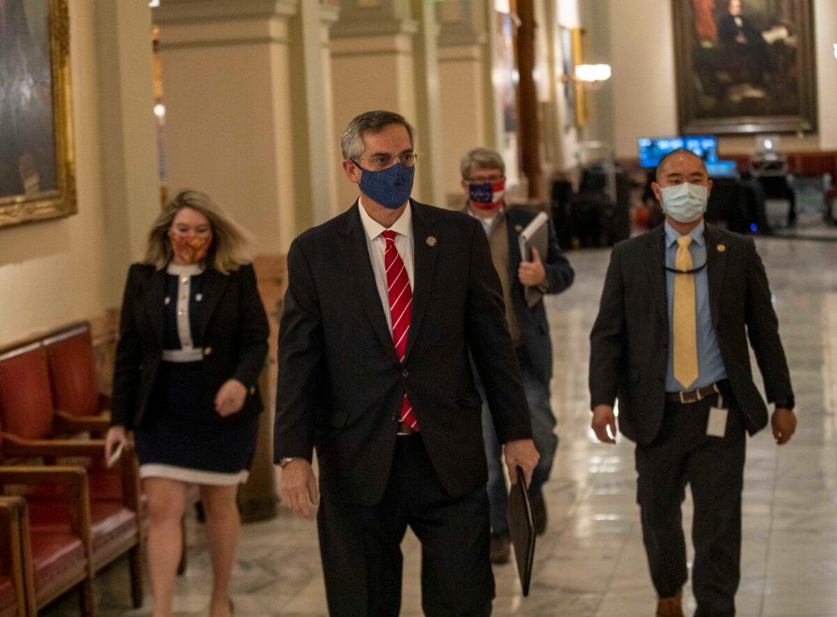 Georgia Secretary of State Brad Raffensperger, center, walks with members of his staff as they make their way to a press conference at the Georgia State Capitol building in Atlanta, Ga., on Dec. 2, 2020. (Alyssa Pointer/Atlanta Journal-Constitution via AP)