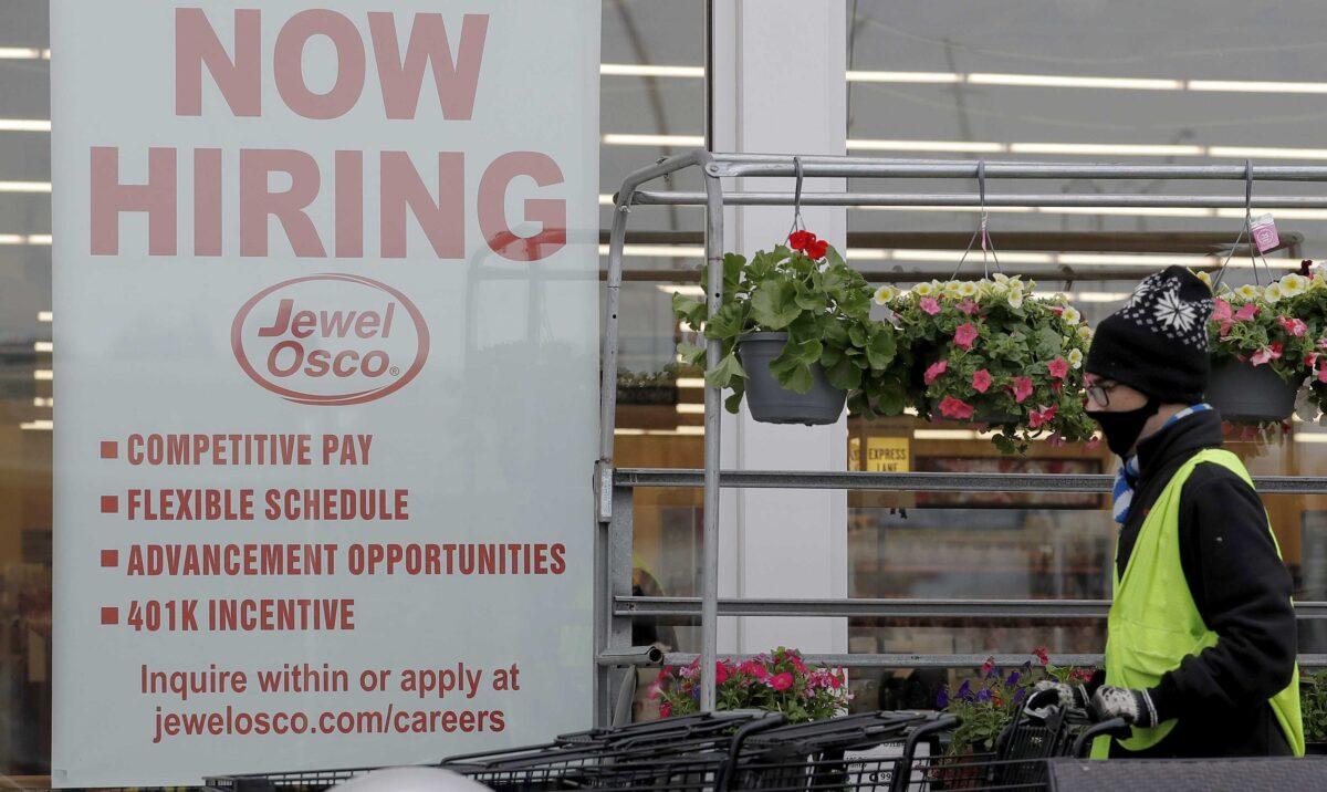 A man pushes carts as a hiring sign shows at a Jewel Osco grocery store in Deerfield, Ill., on April 23, 2020. (Nam Y. Huh/AP Photo)