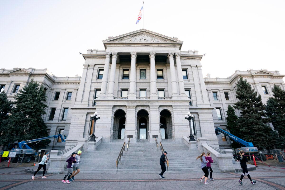 Runners run past the Colorado State Capitol in Denver on Oct. 20, 2019. (Patrick McDermott/Getty Images)